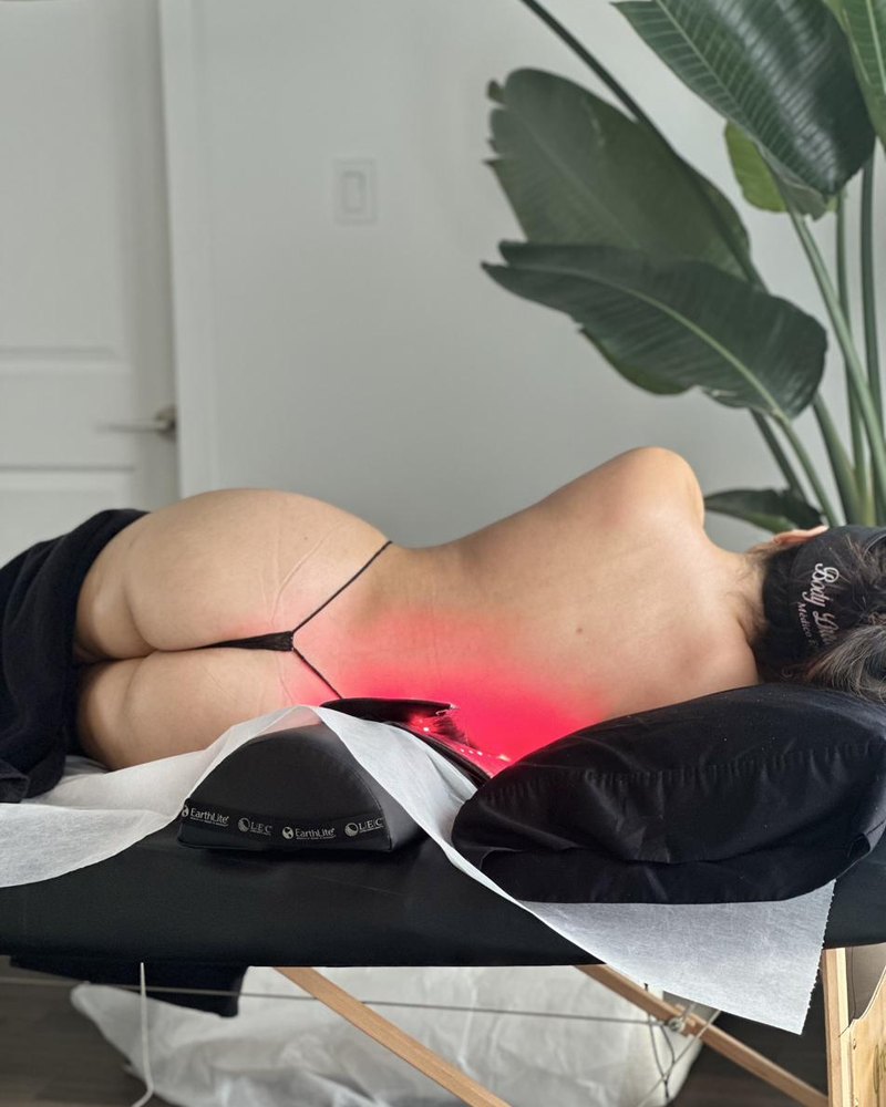 Bandeau de luminothérapie à lumière rouge posé sur le bas du dos d'une cliente en séance